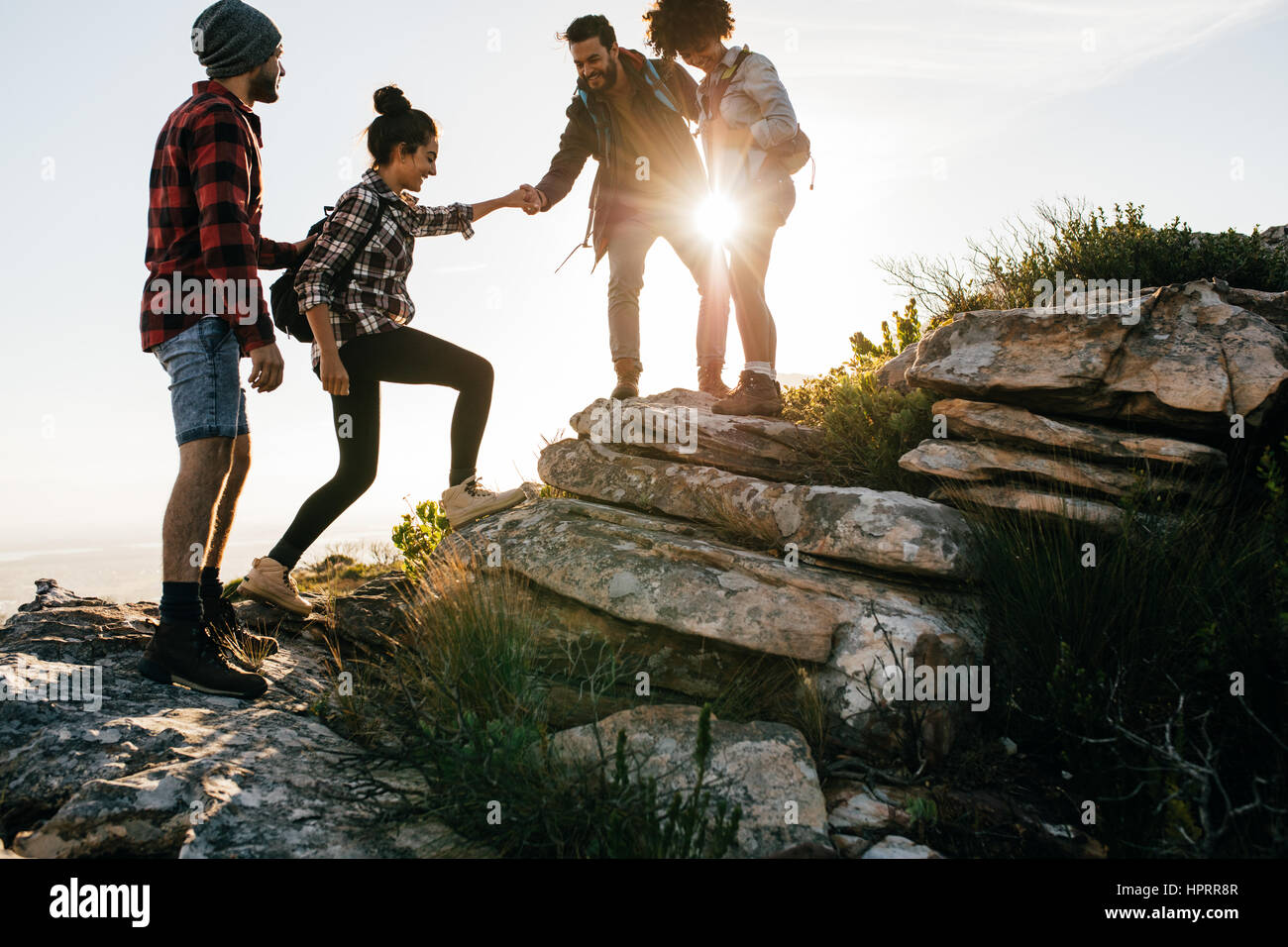 Group of friends hiking in mountain. Four hikers walking on a mountain