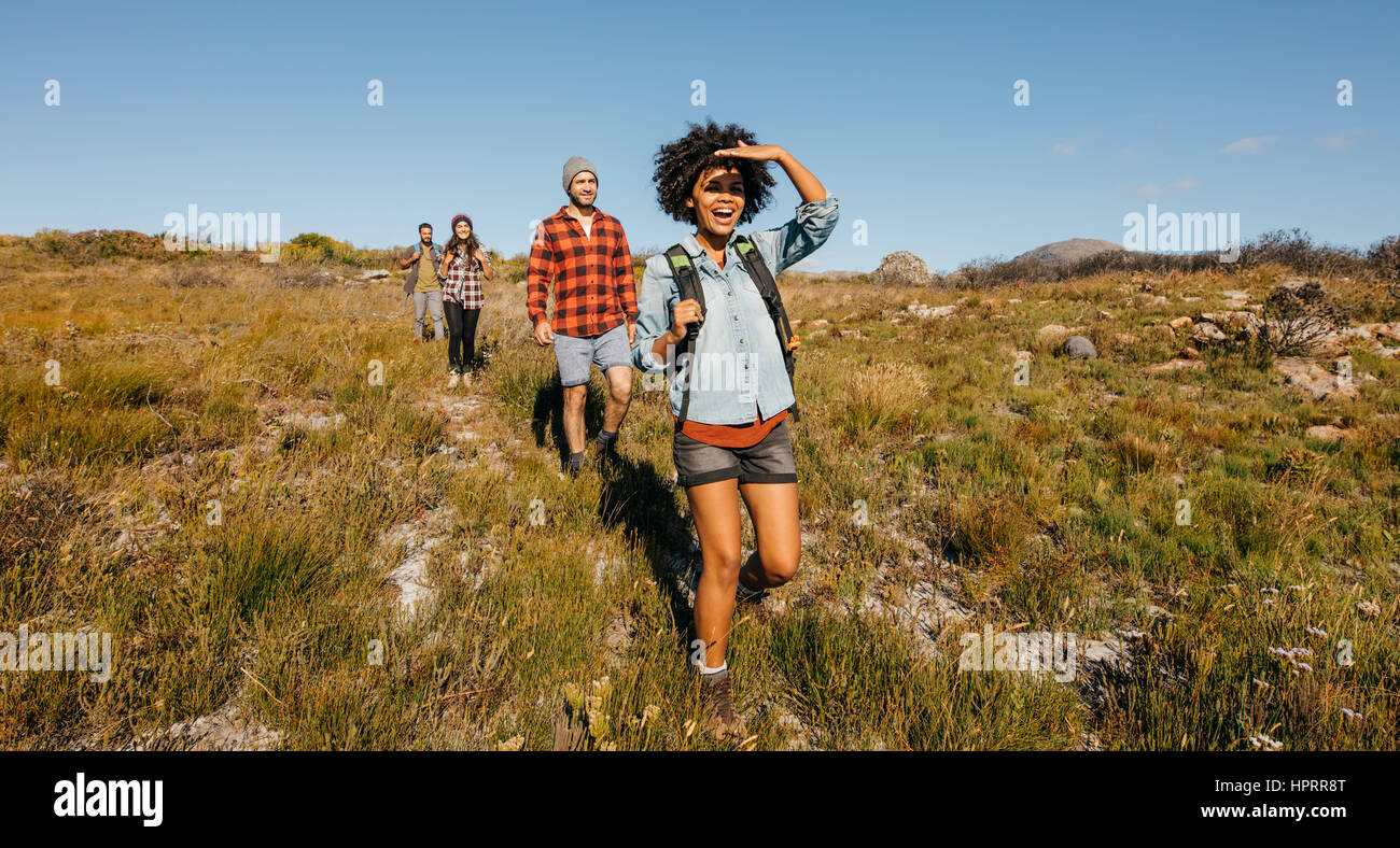 Group of young friends hiking in countryside. Multiracial young people on country walk. Stock Photo