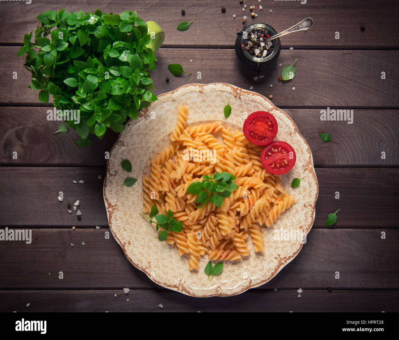 fusilli pasta in tomato sauce, tomatoes decorated with basil on a ...