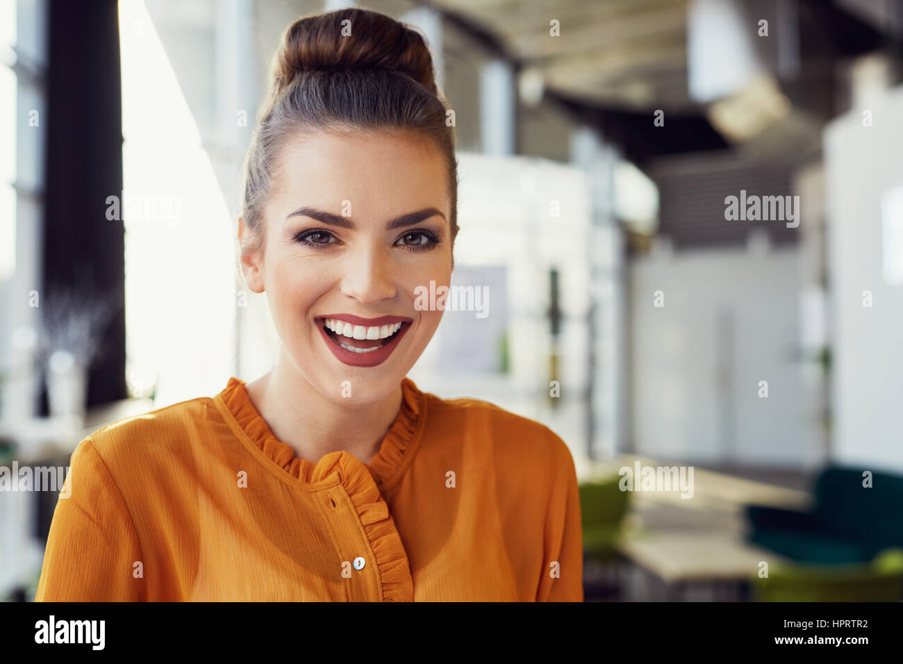 Portrait of beautiful young woman smiling in modern office Stock Photo ...
