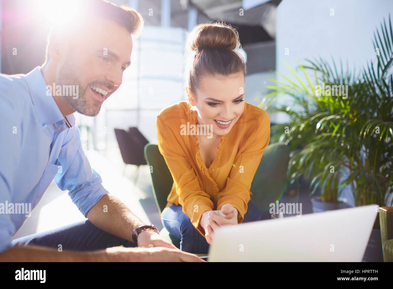 Happy young bussinesman and woman sat working together in office with ...