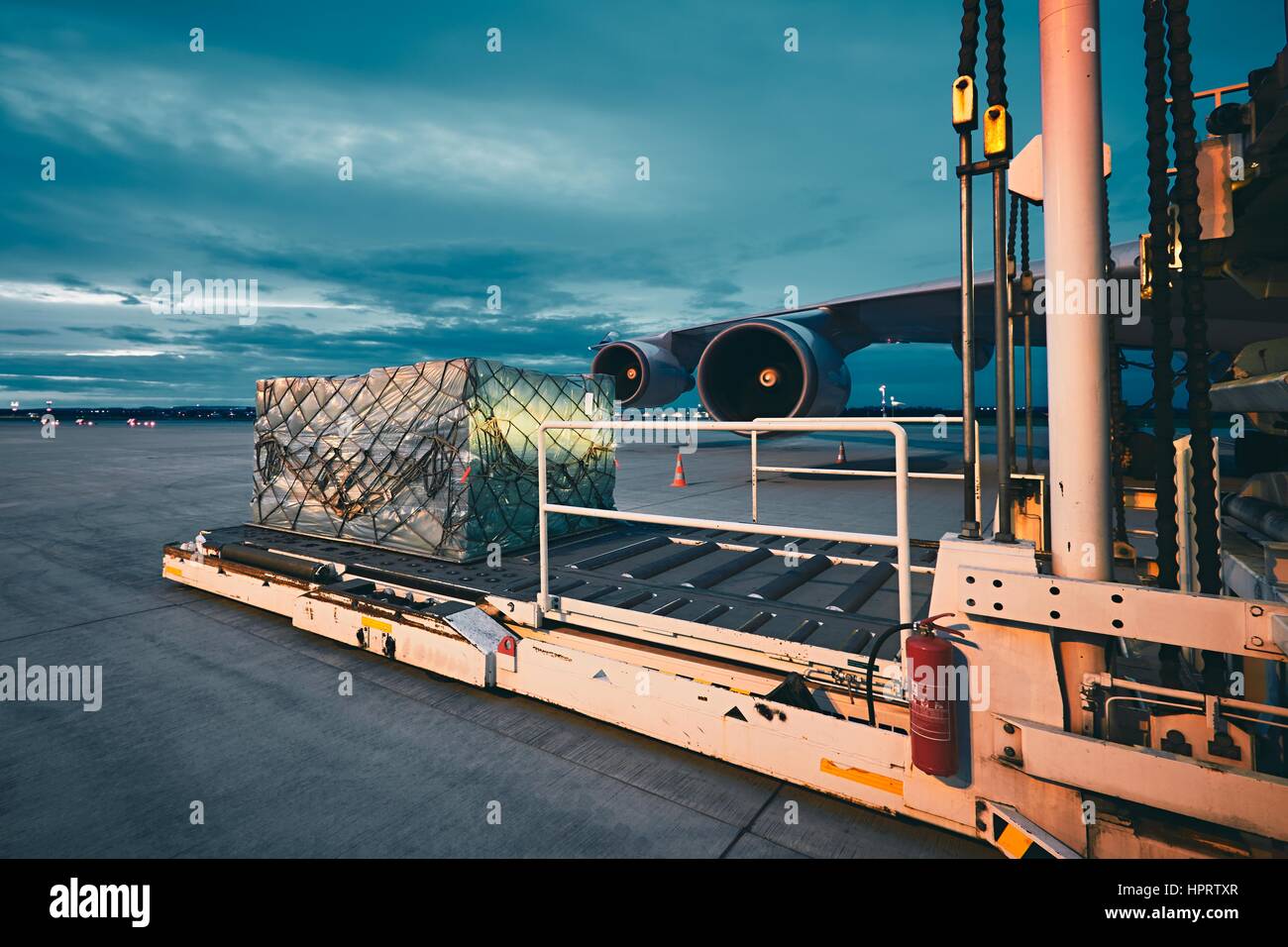 Airport at the dusk. Loading of cargo to the freight aircraft. Stock Photo