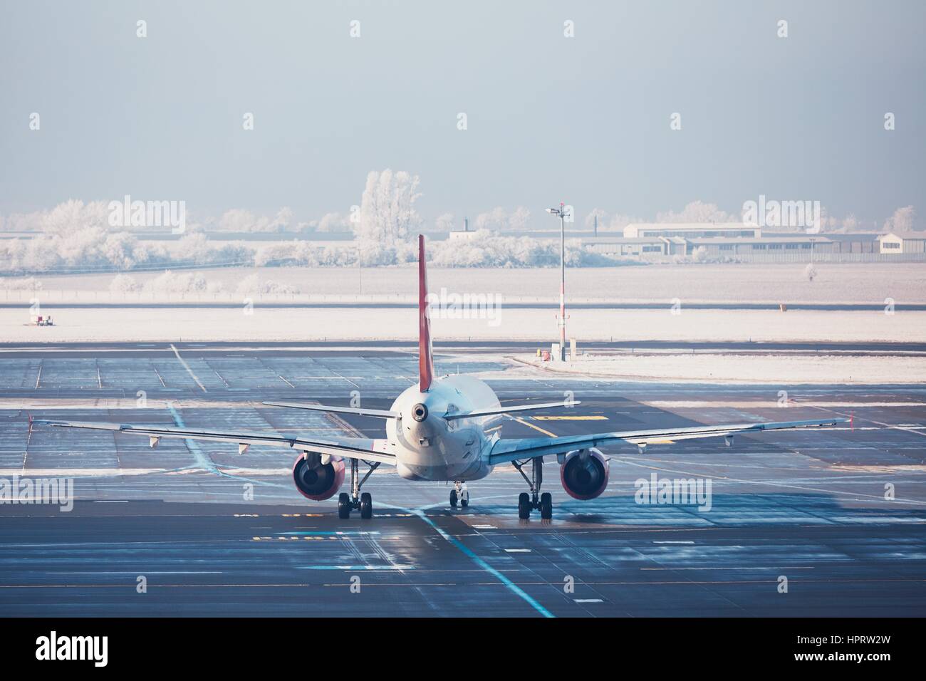 Airport in winter. Airplane is taxiing to the runway for take off. Stock Photo