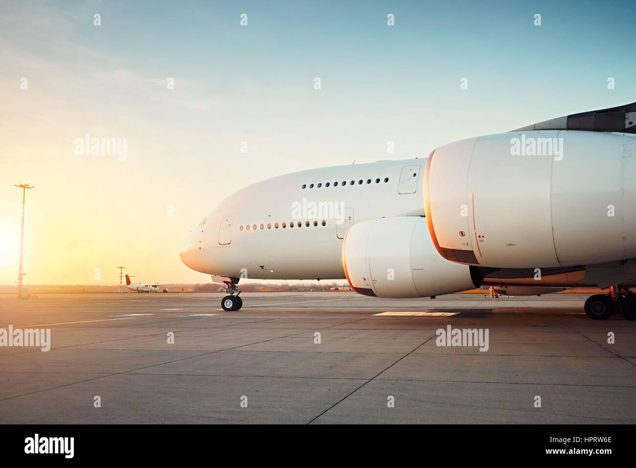 Traffic of the airport at the sunset. Huge airplane is taxiing to the runway - selective focus Stock Photo