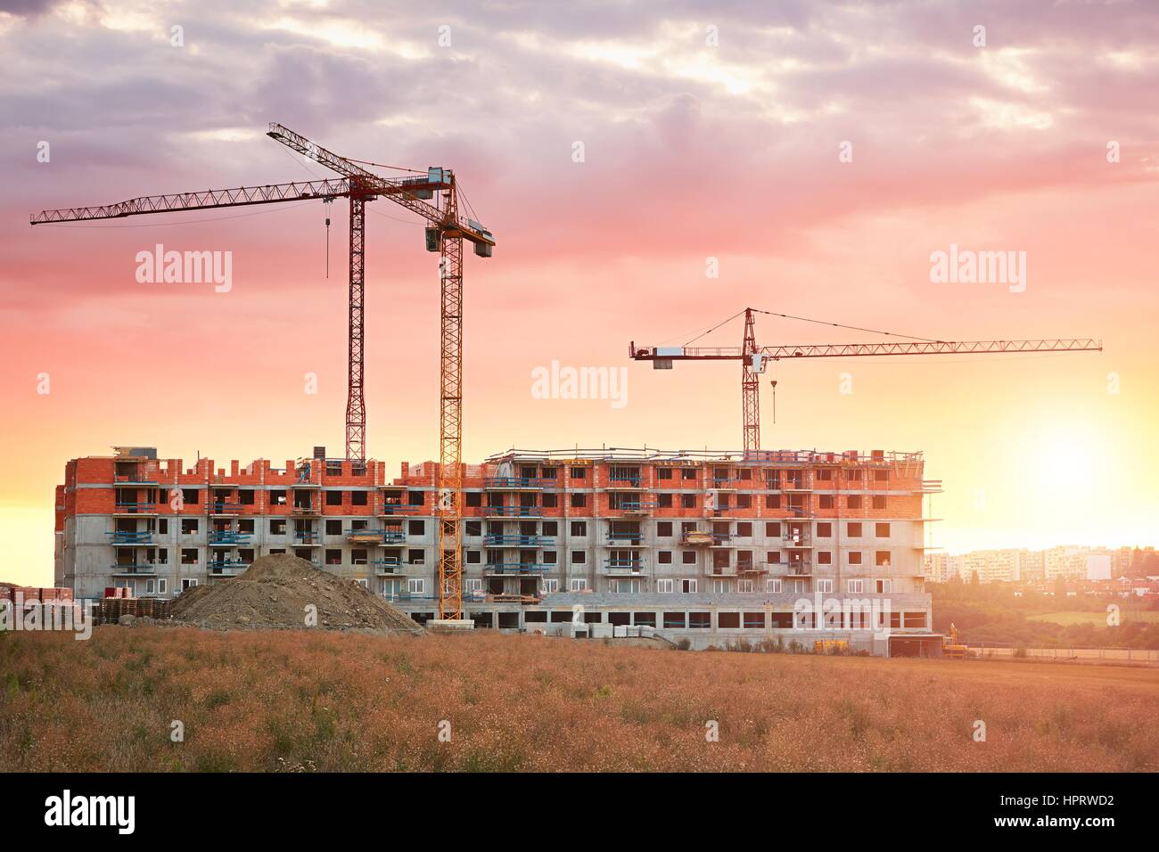 Construction site with cranes at the amazing sunset. Construction of the new residential building. Prague, Czech Republic. Stock Photo