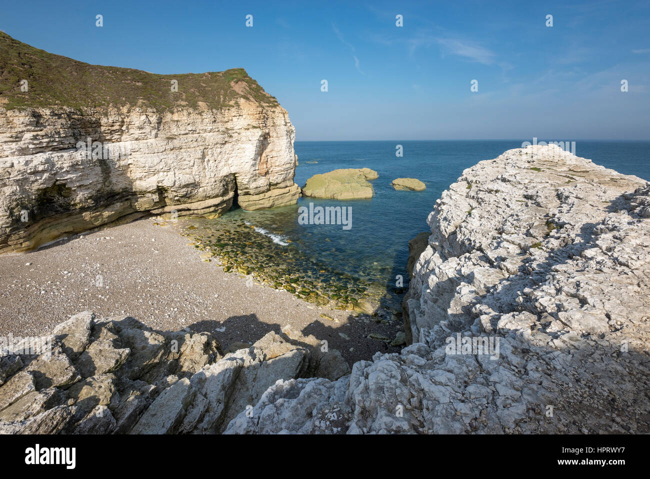 Beautiful pebbly beach at Thornwick bay, Flamborough head on the  east coast of England. A popular tourist destination with stunning scenery. Stock Photo