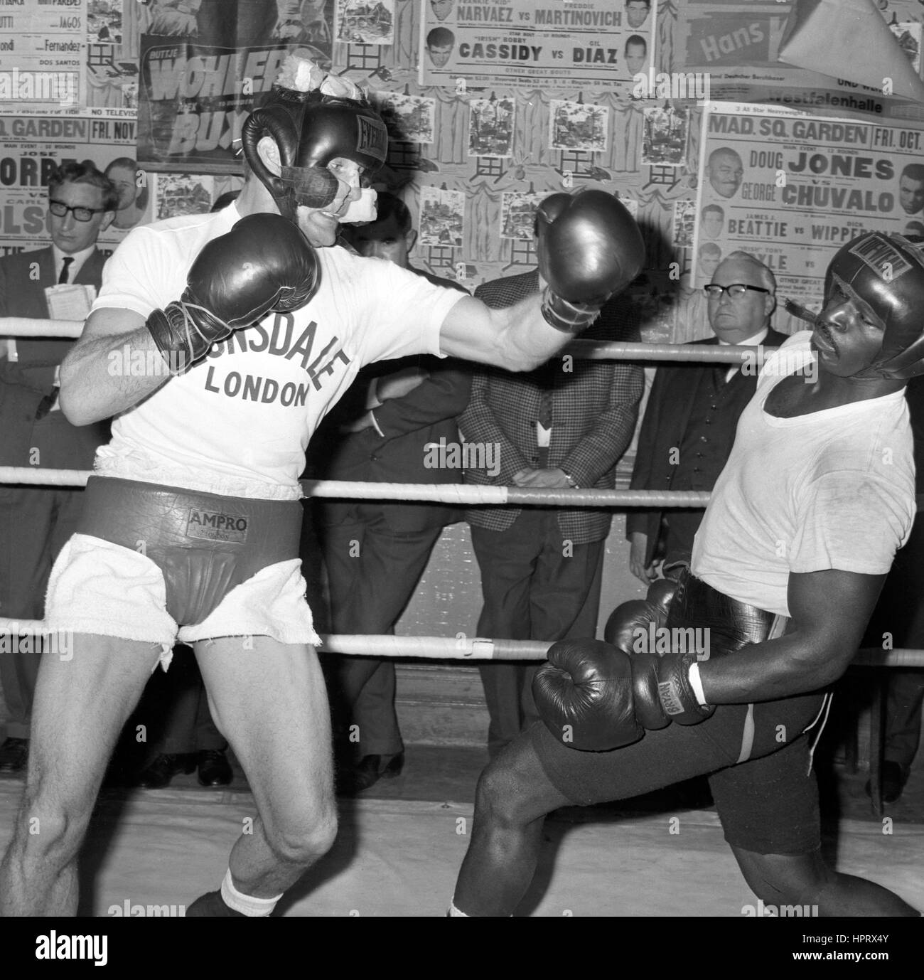 Henry Cooper (l) lets his famous left-hook go at sparring partner Jim Fletcher during training at the  Thomas A Becket Gymnasium, Old Kent Road, London. Stock Photo