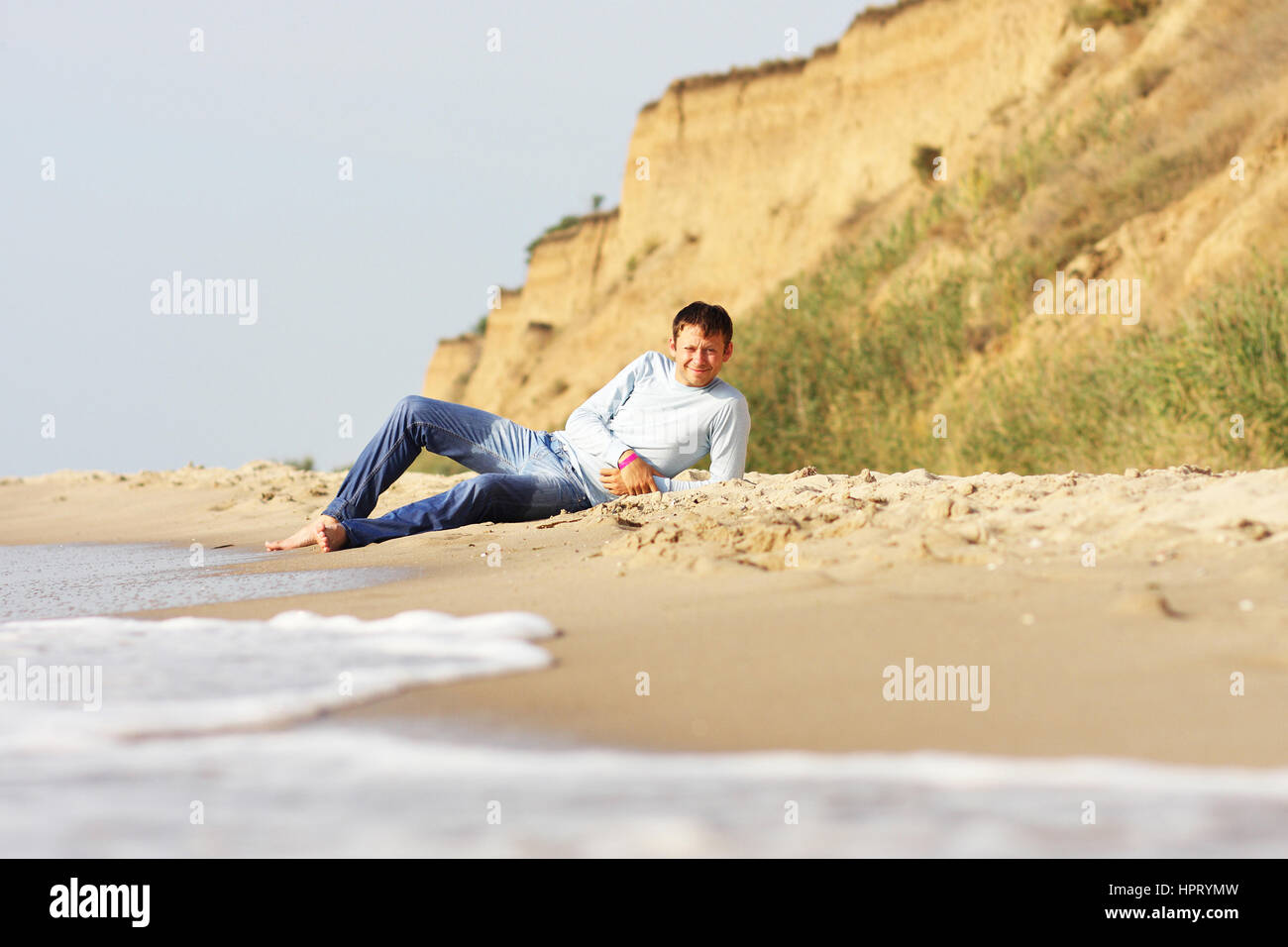 Young white happy man relax on the cost on jeans Stock Photo