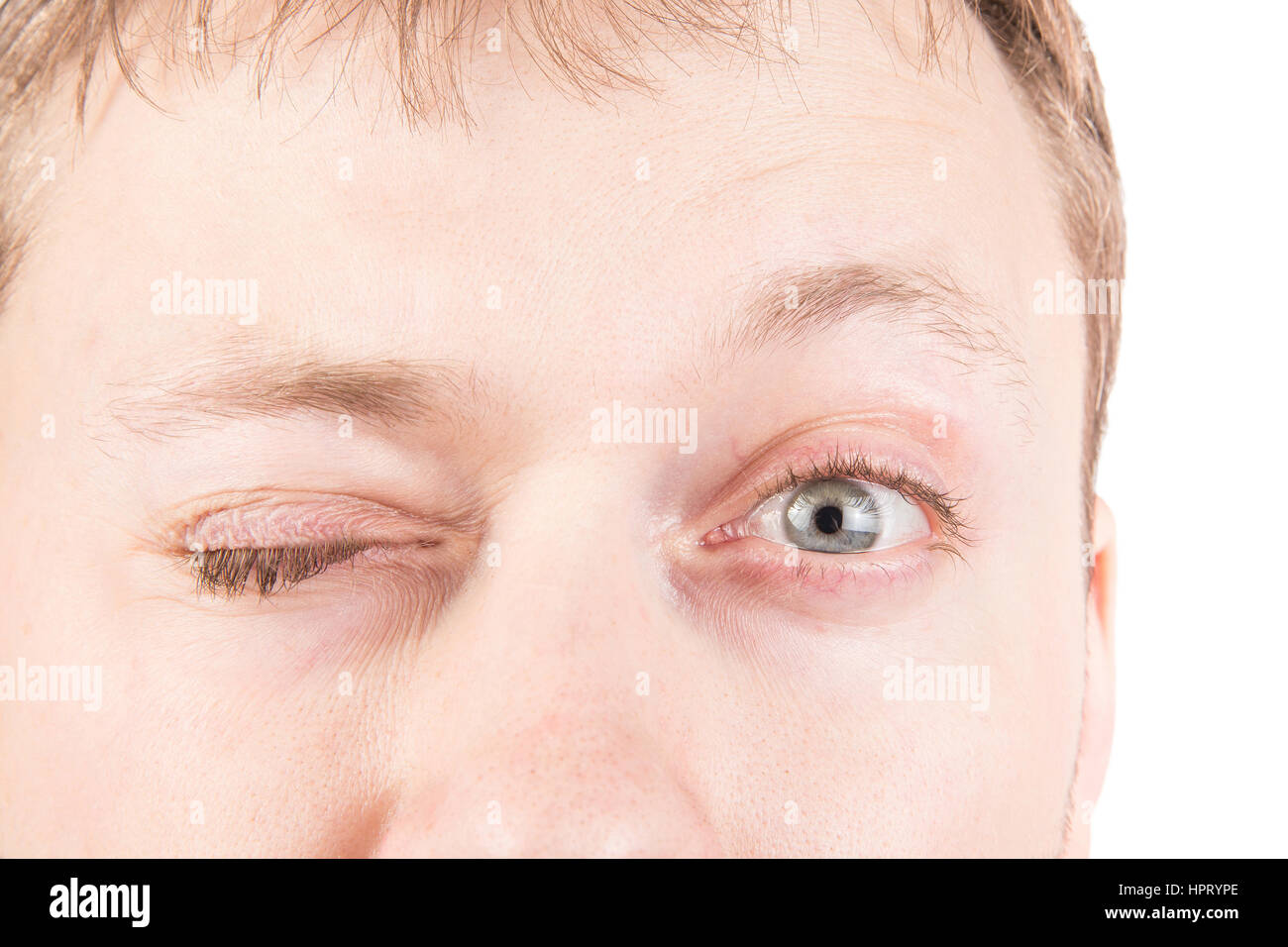Man's blinking gray eyes close up Stock Photo