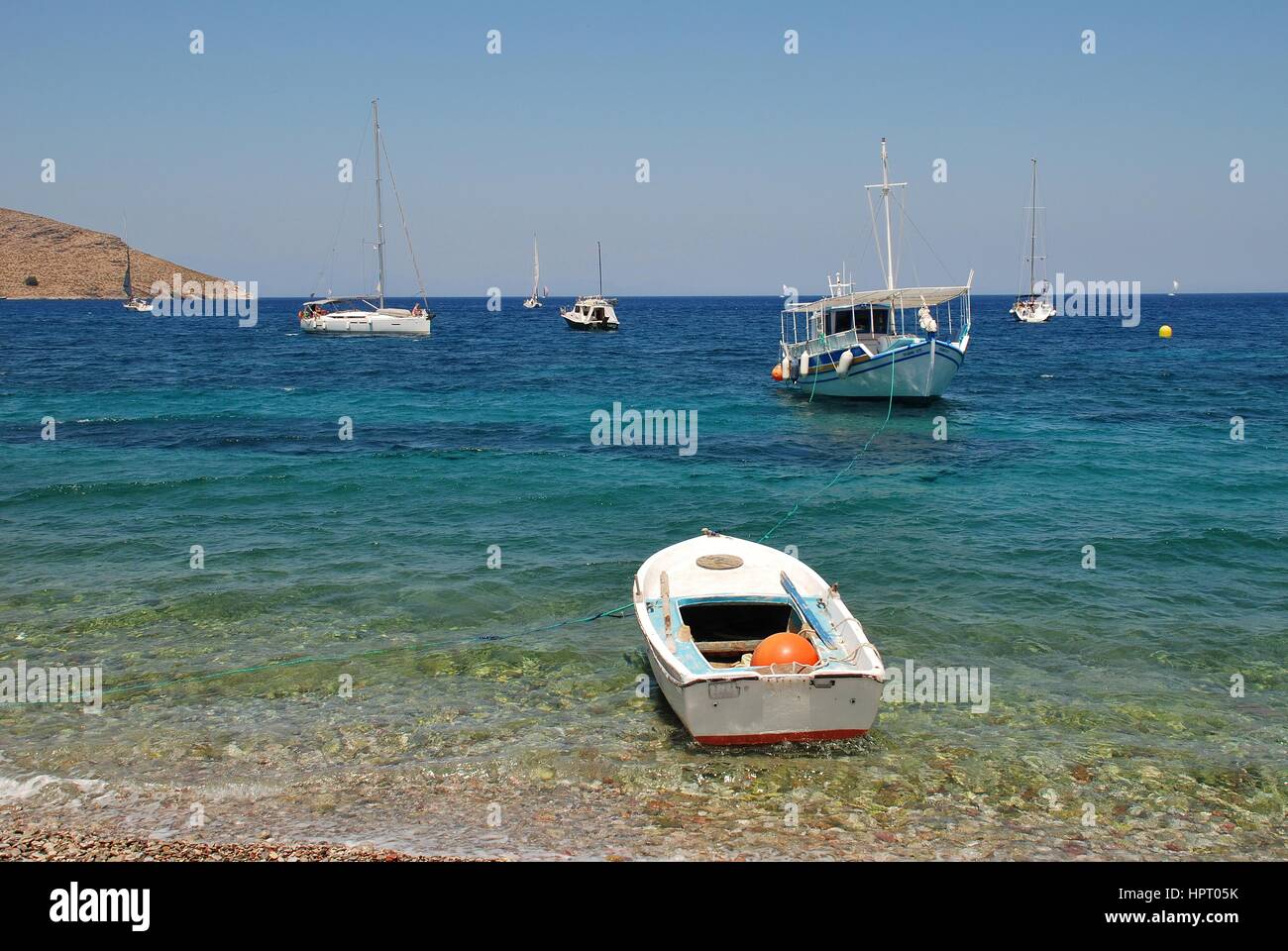 Small boats moored in Livadia harbour on the Greek island of Tilos on July 19, 2016. The 14.5km long island has a population of around 780 people. Stock Photo