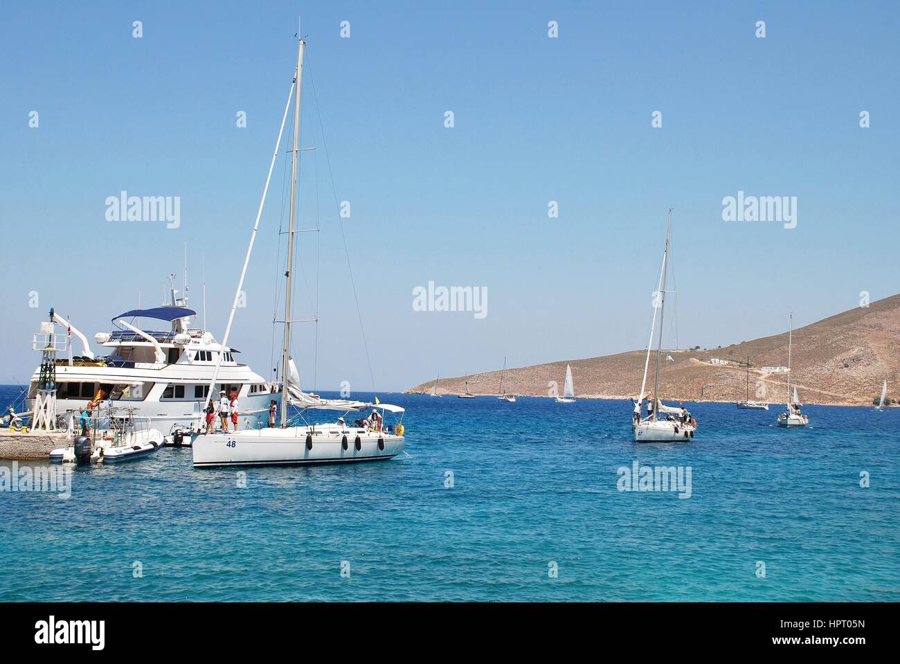 Competitors in the Rhodes Cup yacht race arrive in Livadia harbour on the Greek island of Tilos on July 19, 2016. The race is in its 20th year. Stock Photo