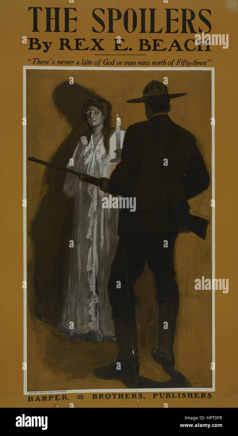 Poster advertisement for a book titled The Spoilers by Rex E Beach which displays a man carrying a rifle and a woman dressed in a nightgown holding a candle, 1903. From the New York Public Library. Stock Photo