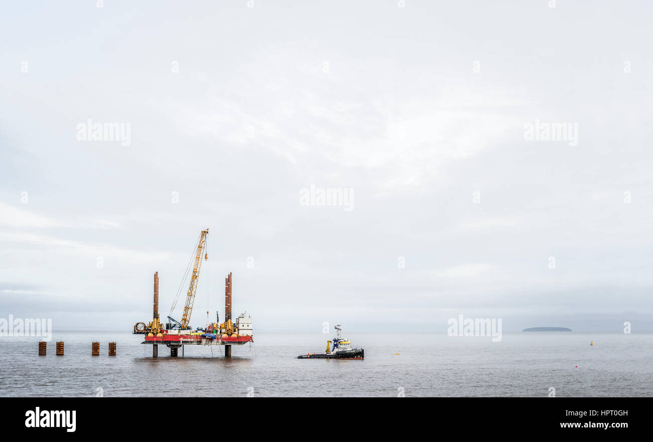 Offshore rig and boat in the Bristol channel,druring the construction of Hinhley C power station. Stock Photo