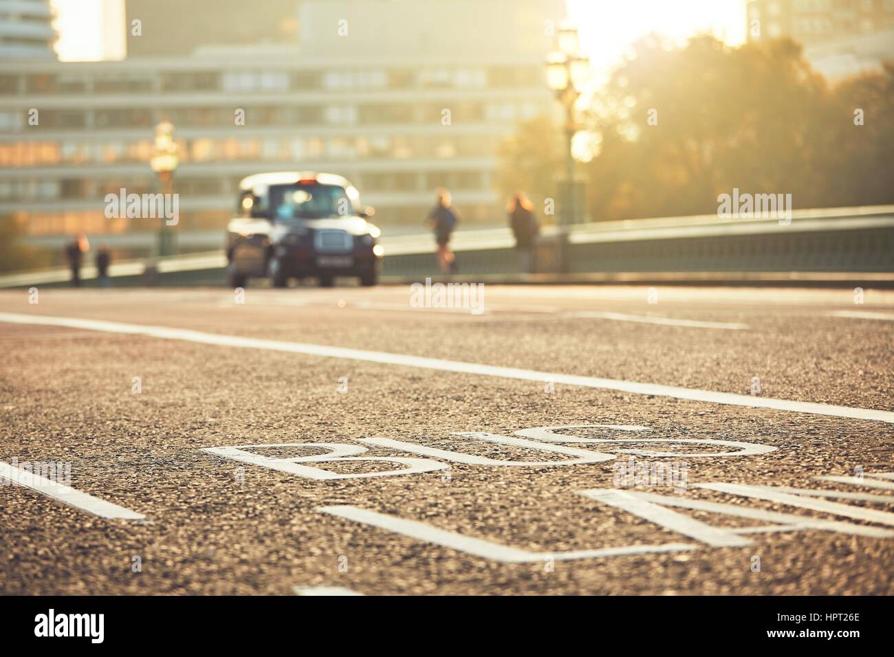 Daily life in the city. Bus lane and black taxi car on the street. London, The United Kingdom of Great Britain and Northern Ireland Stock Photo