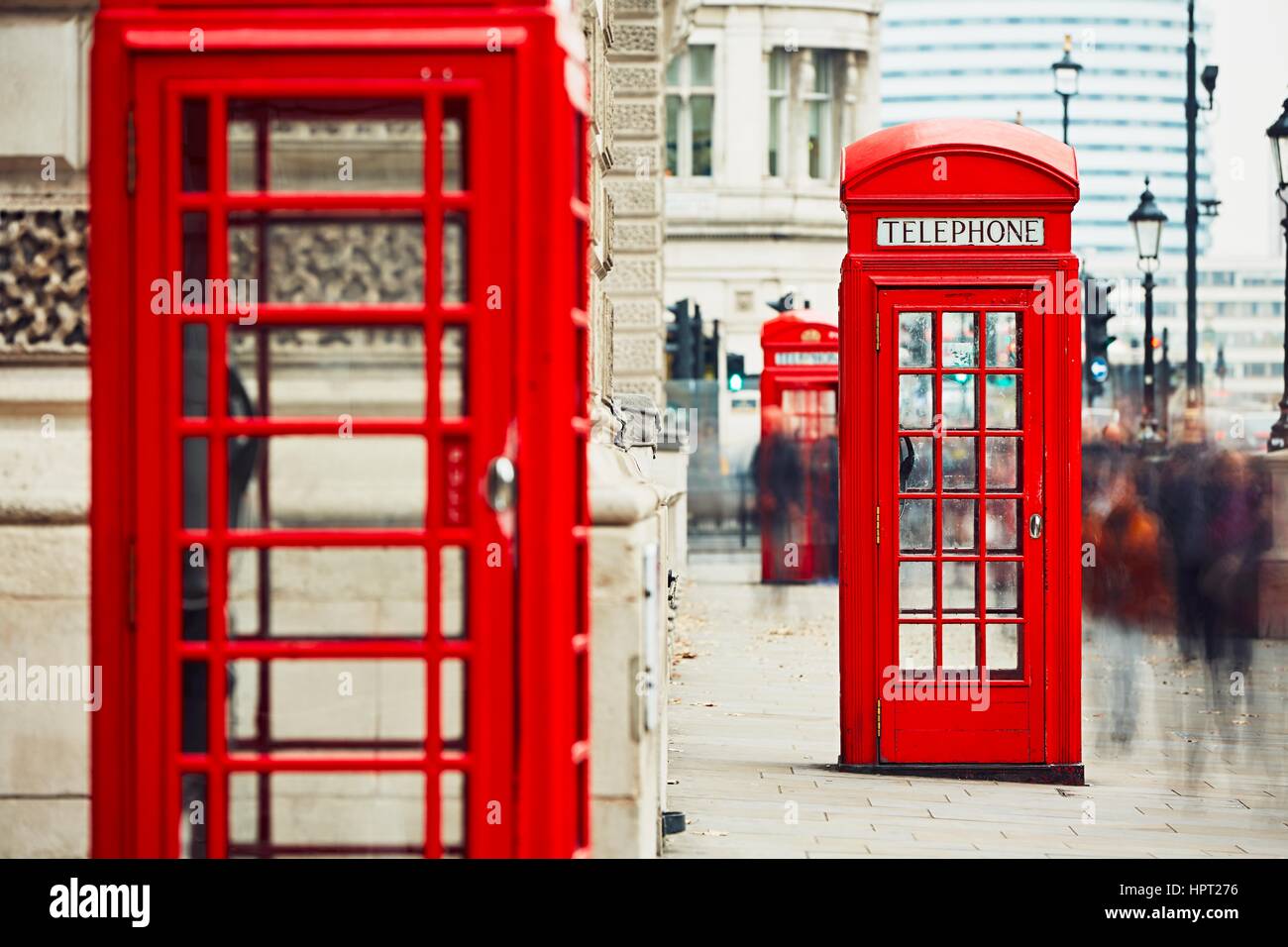 Crowd of people and red telephone boxes on the street in London, The United Kingdom of Great Britain and Northern Ireland Stock Photo