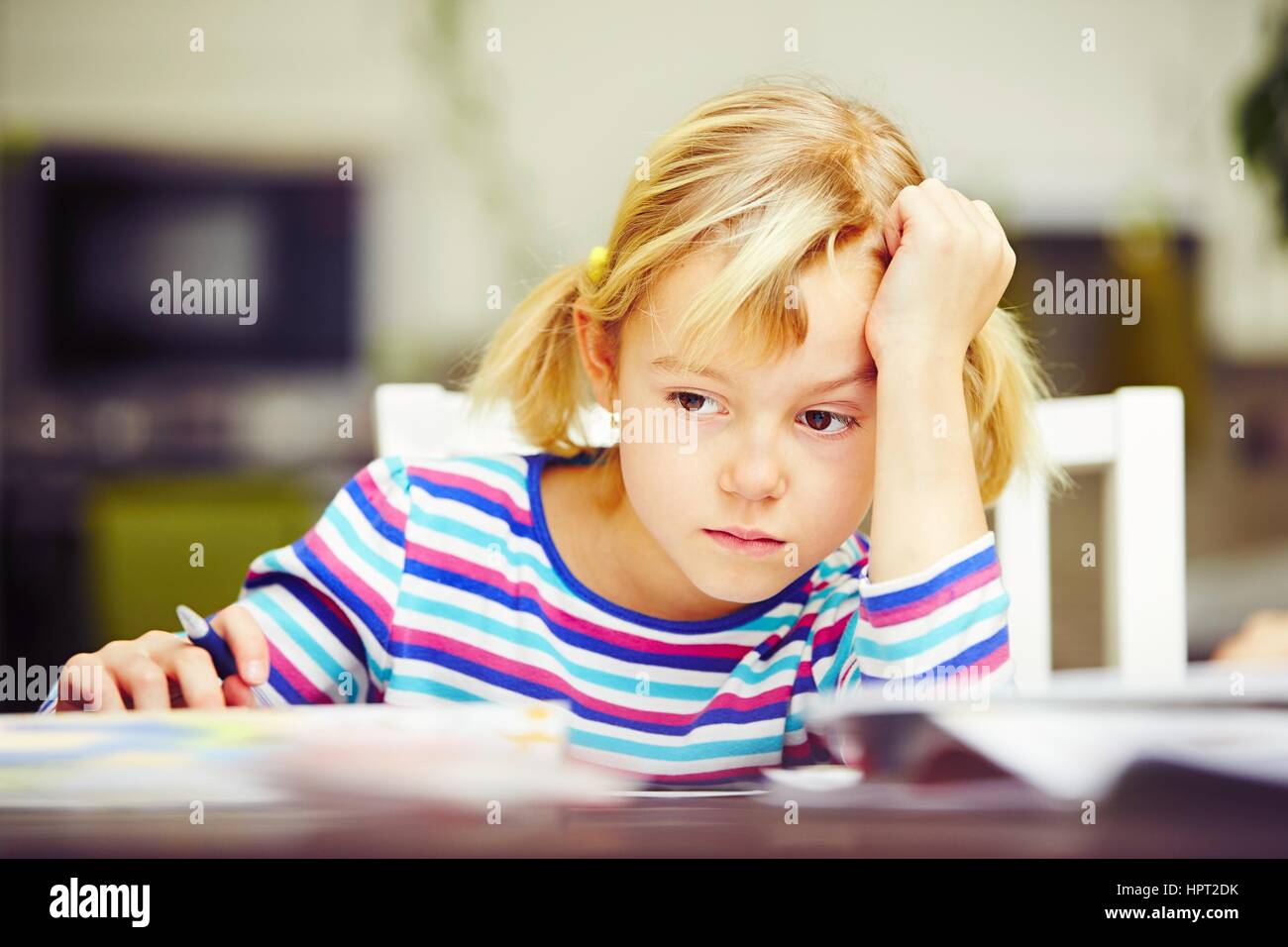 Little girl is doing his homework for elementary school. Stock Photo