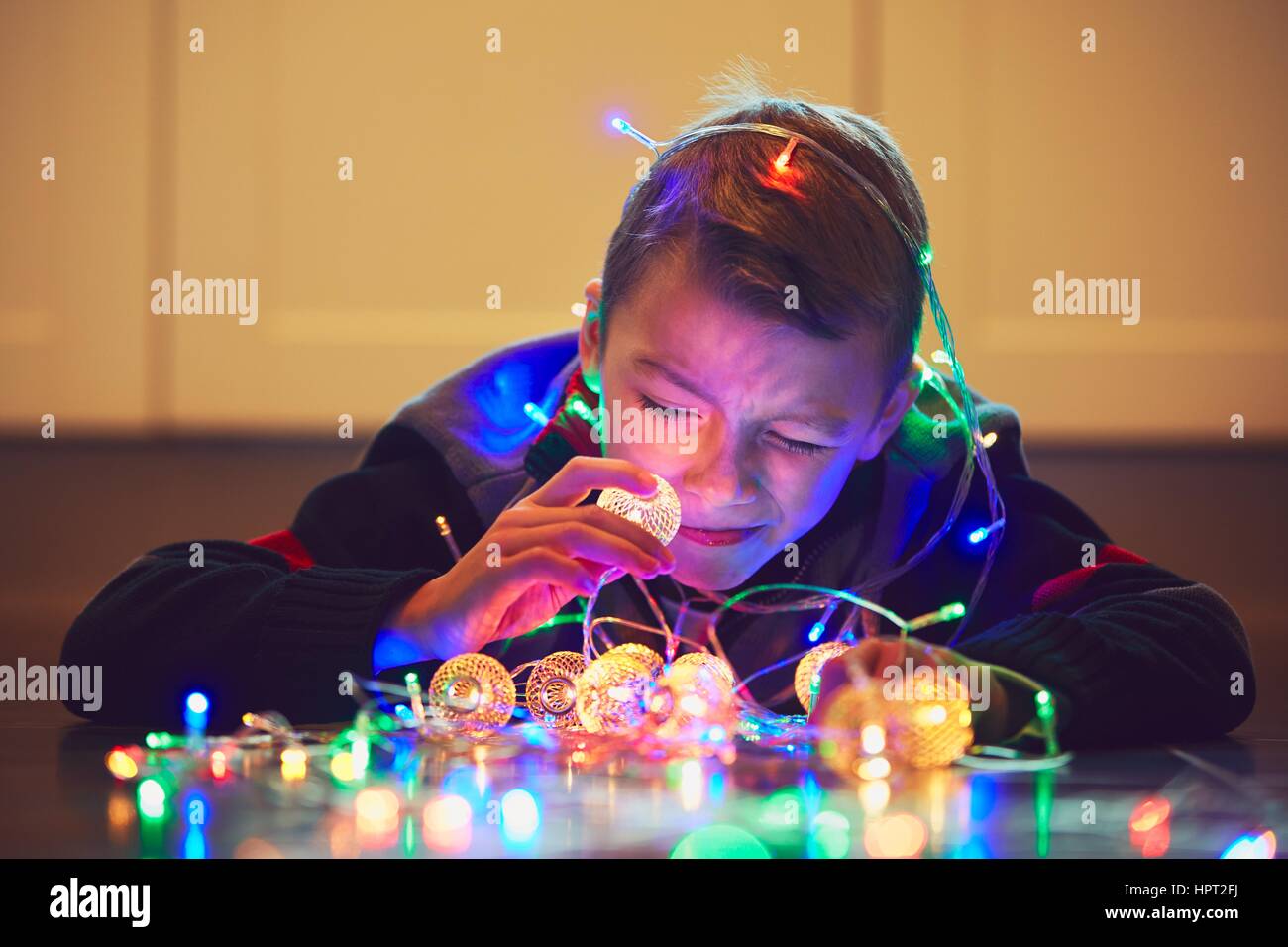 Christmas surprise is coming. Cute little boy playing with magic Christmas light at the home. Stock Photo