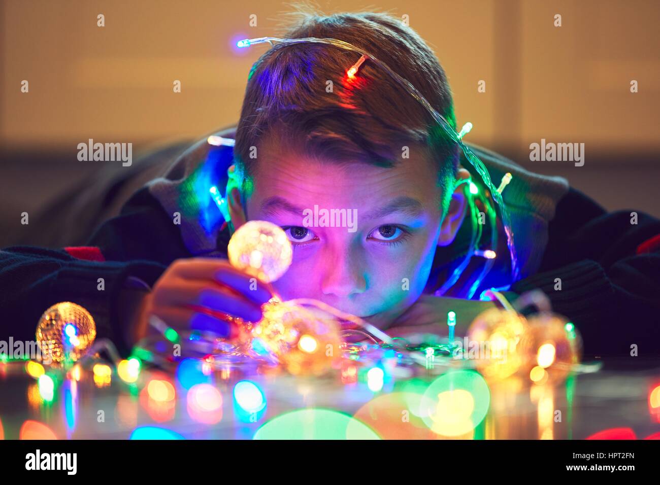 Christmas surprise is coming. Cute little boy playing with magic Christmas light at the home. Stock Photo