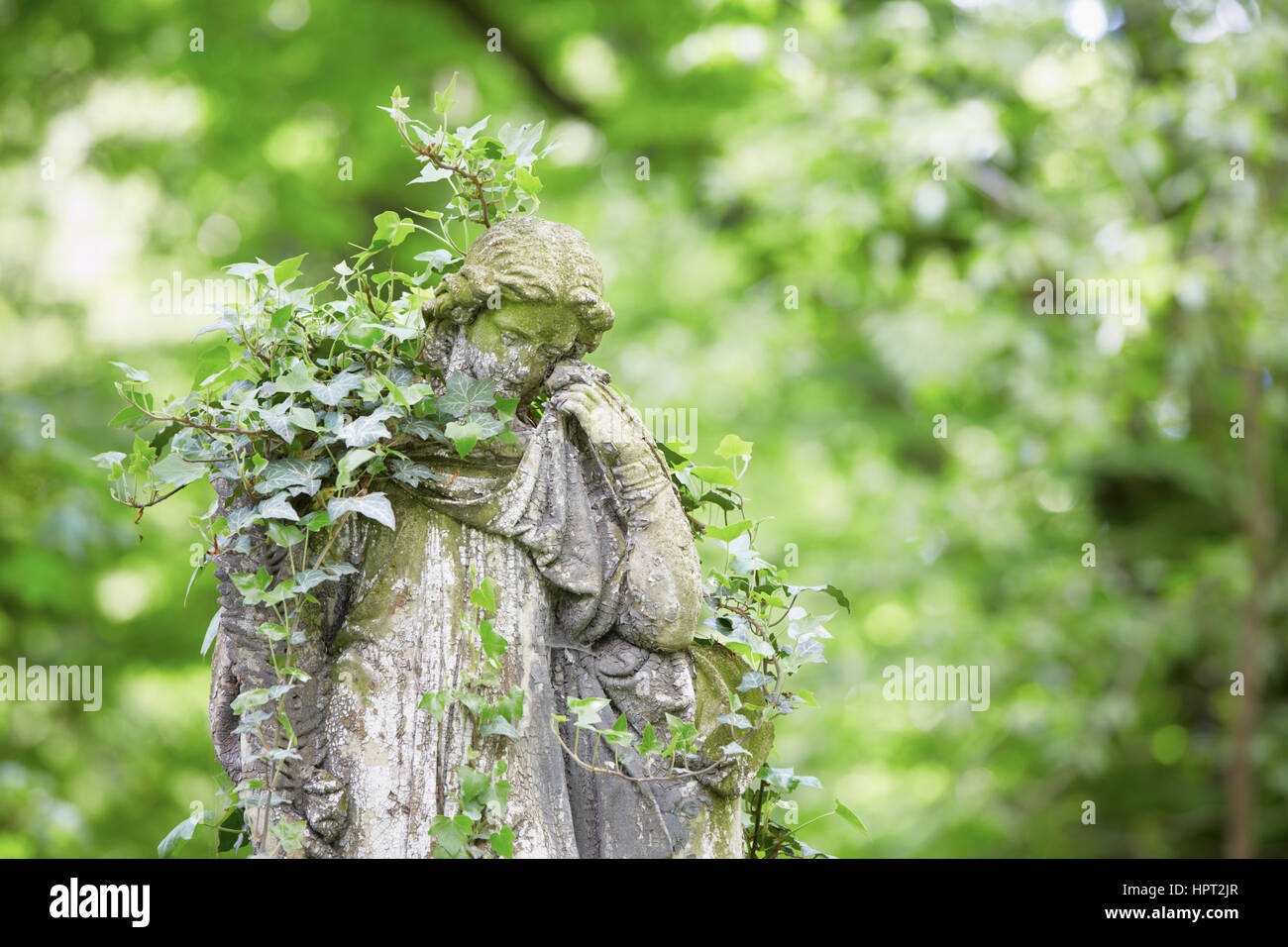 Sad angel statue on old cemetery Stock Photo