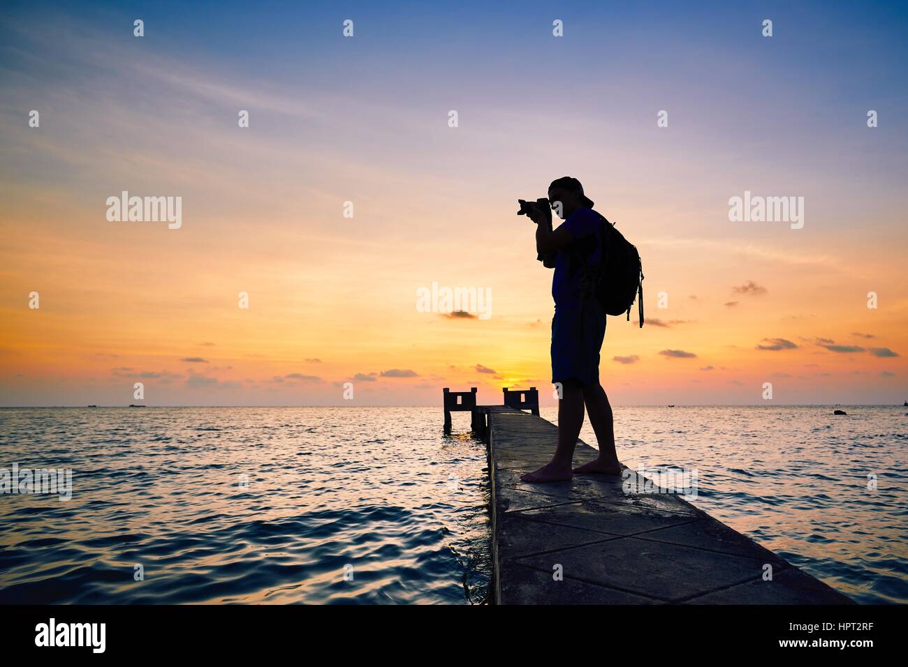 Young photographer is taking photos at the sunset. Stock Photo