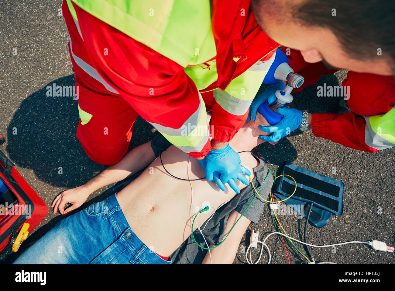 Cardiopulmonary resuscitation. Rescue team (doctor and a paramedic) resuscitating the man on the street. Stock Photo