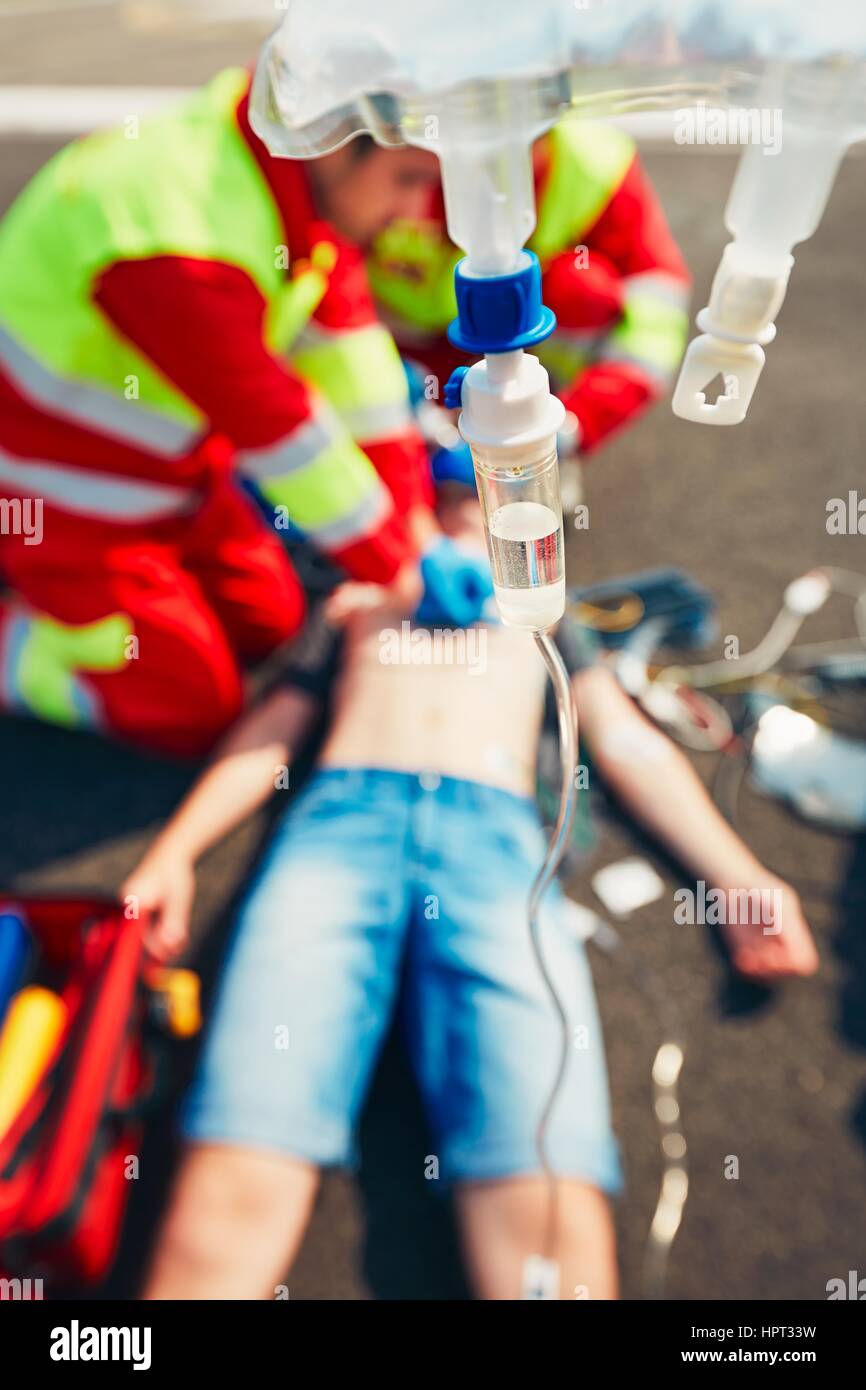 Cardiopulmonary resuscitation. Rescue team (doctor and a paramedic) resuscitating the man on the street. Stock Photo