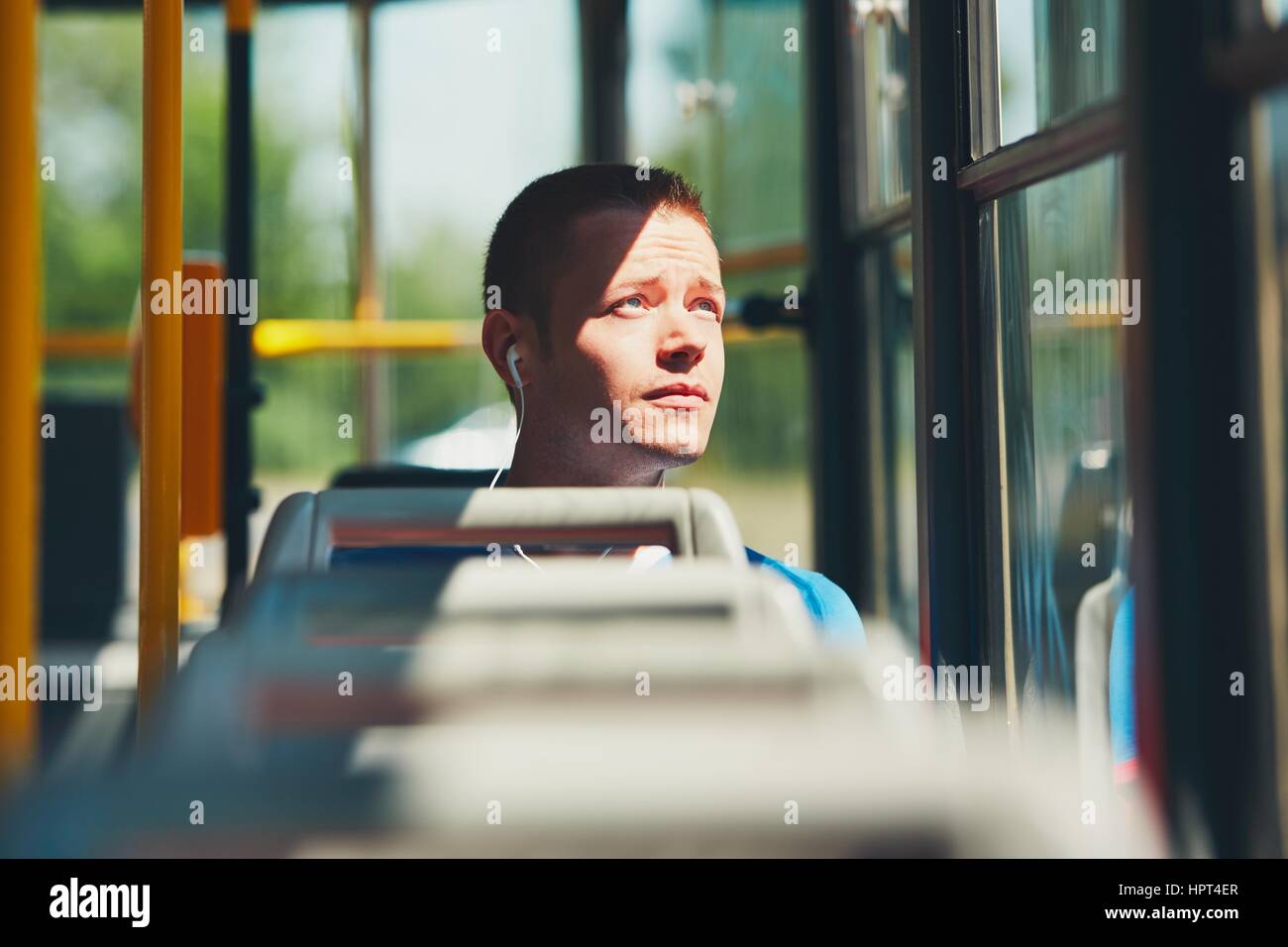 Everyday life and commuting to work by public transportation. Handsome young man is traveling by tram. Stock Photo
