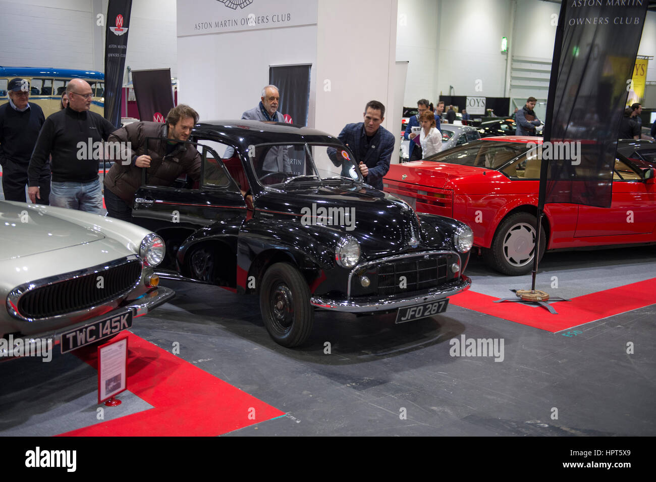 ExCel, London, UK. 23rd February, 2017. Opening day of the 2017 Classic Car Show with spectacular coupes, saloons and racing cars displayed around the Grand Avenue. A late arrival to the Car Club Square is pushed into position. Credit: Malcolm Park editorial/Alamy Live News. Stock Photo