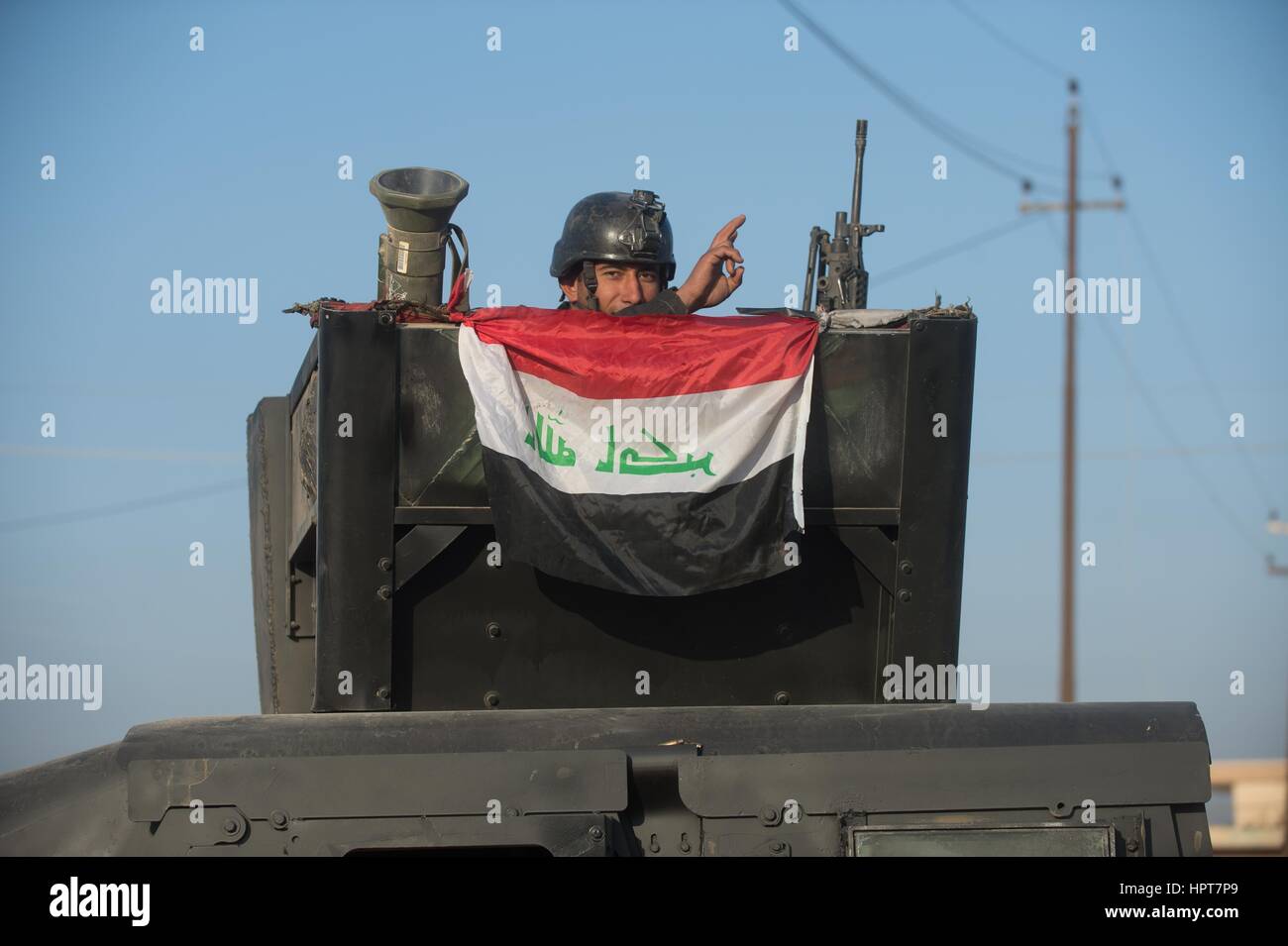 Mosul, Iraq. 23rd Feb, 2017. An Iraqi Special Forces soldier waves in a convoy heading to the frontline as the Iraq government continues to capture territory from ISIS February 23, 2017 in Mosul, Iraq. Iraqi forces moved into western Mosul taking full control of the international airport on the southwestern edge of the city. Credit: Planetpix/Alamy Live News Stock Photo