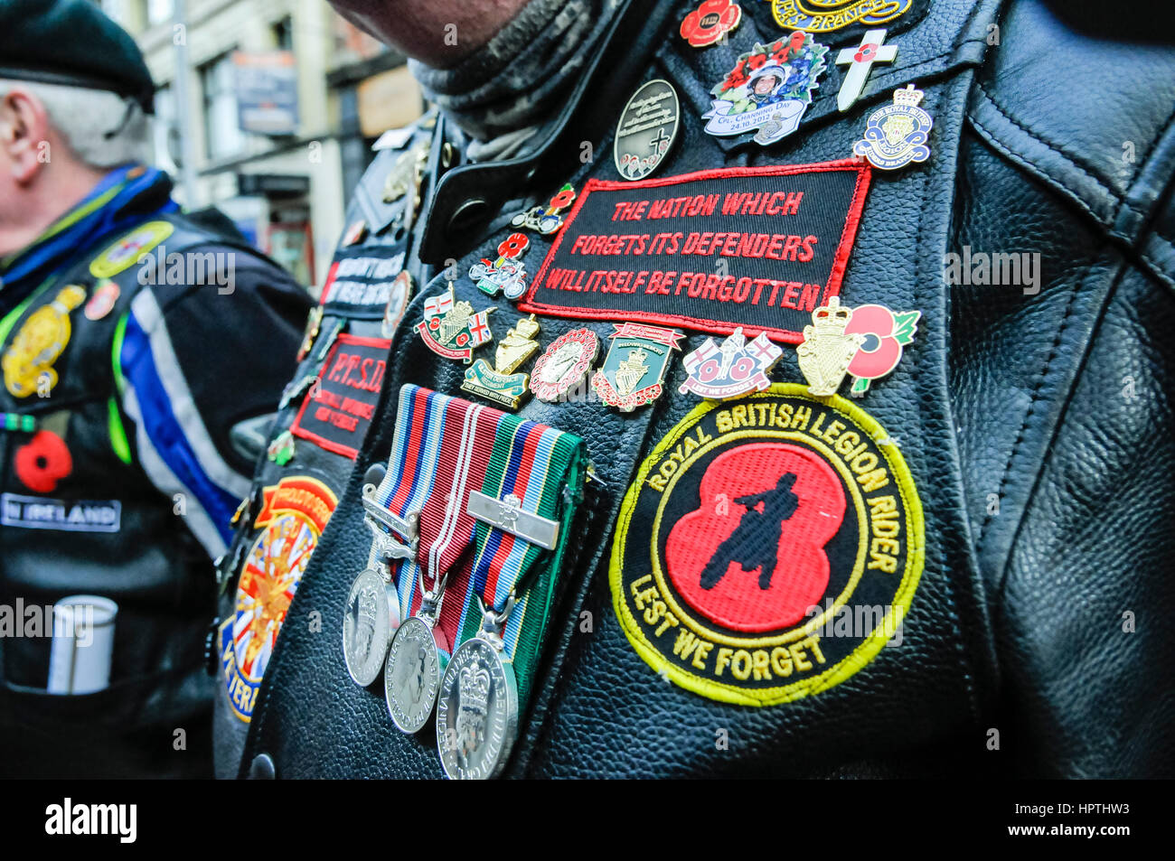 Belfast, Northern Ireland. 25 Feb 2017 - A former soldier wears a leather motorcycle jacket with medals, badges and patches in support of serving and ex-troops. Stock Photo