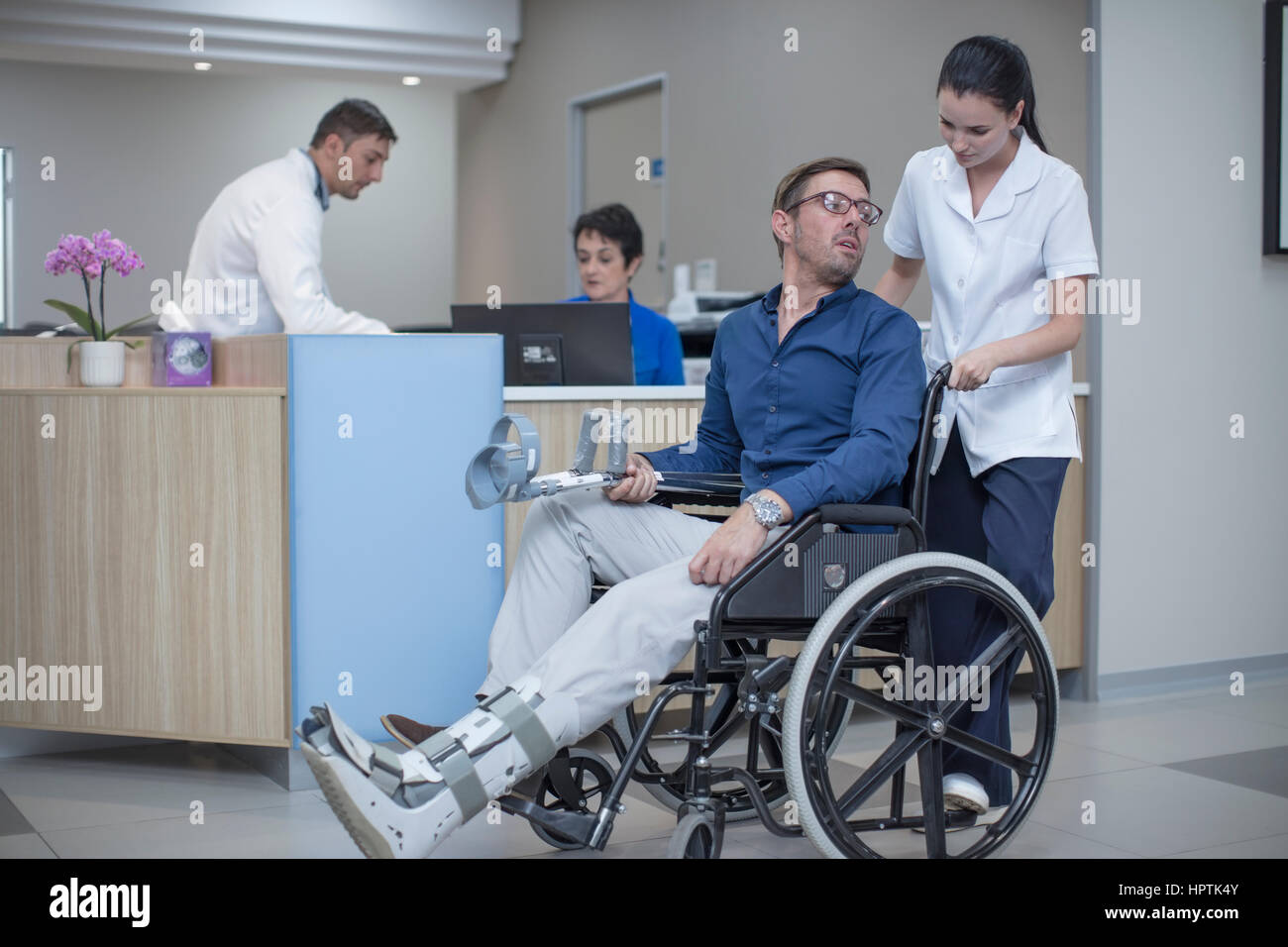 Nurse pushing patient in wheel chair through hospital Stock Photo - Alamy