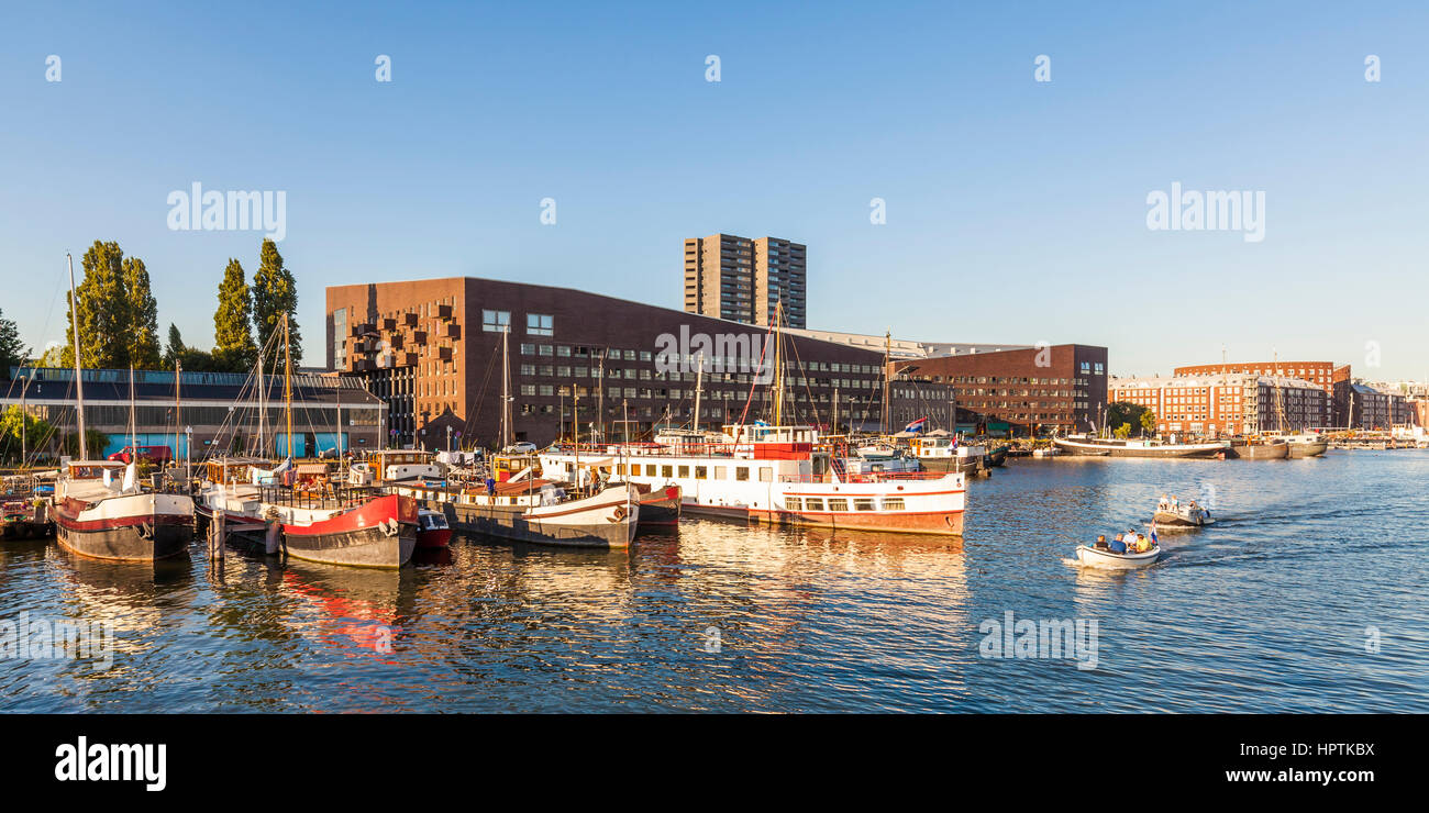Netherlands, Amsterdam, KNSM Island with Piraeus apartment building and houseboats in the foreground Stock Photo