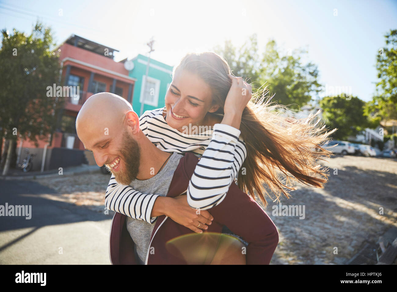 Couple playing piggyback ride in park Stock Photo - Alamy