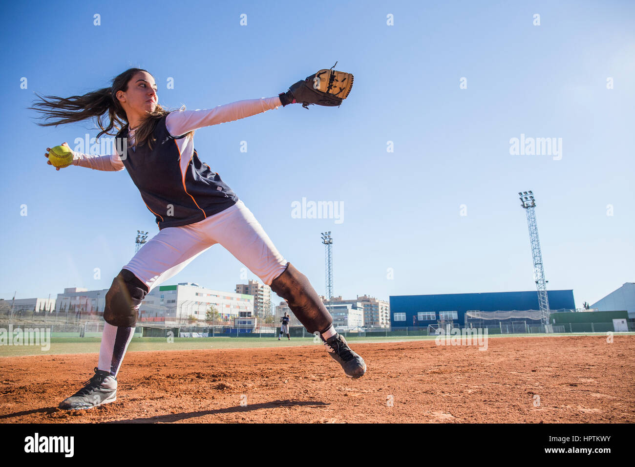 Female baseball player throwing the ball during a baseball game Stock Photo