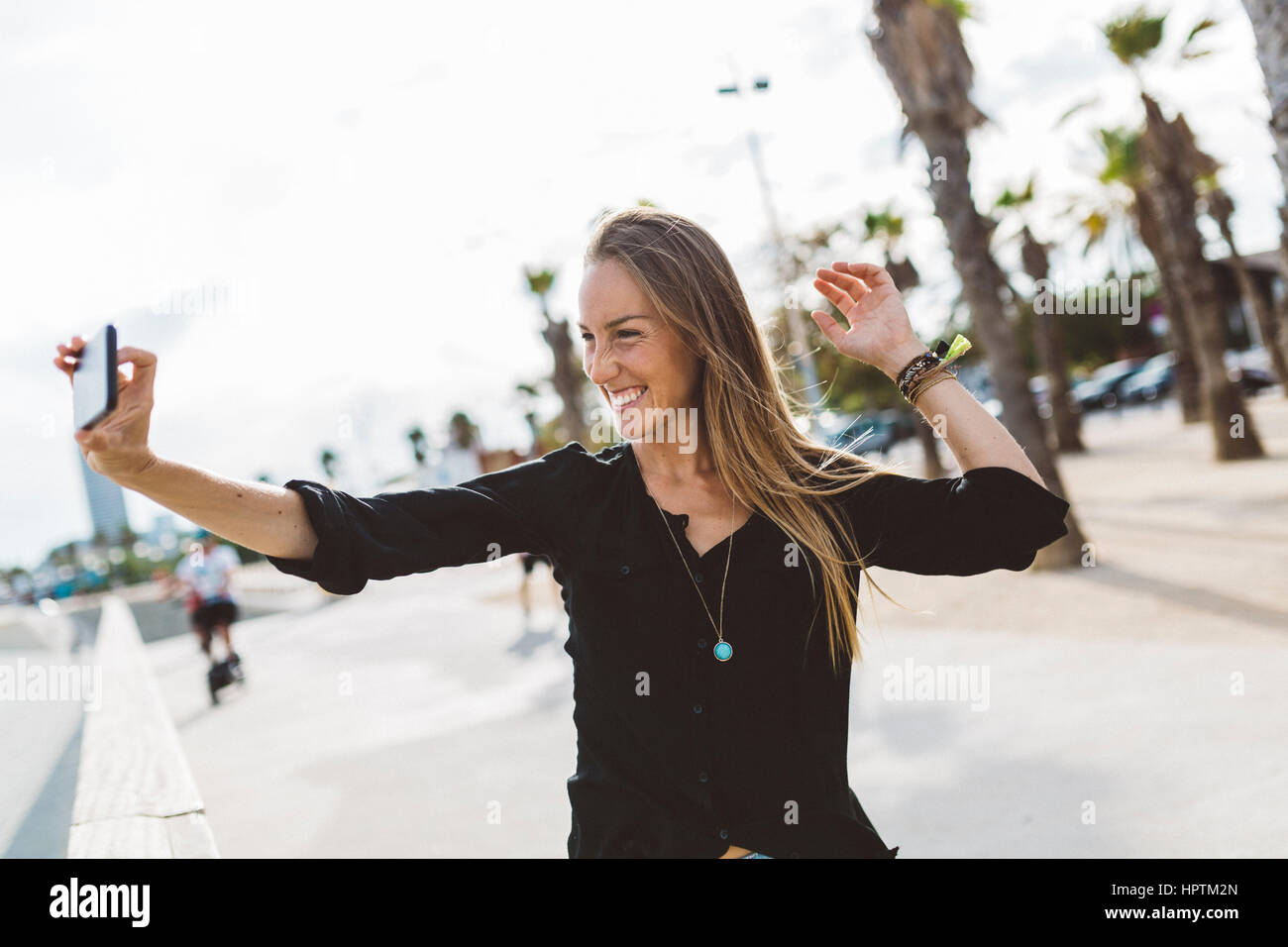 Happy young woman taking a selfie on waterfront promenade Stock Photo ...