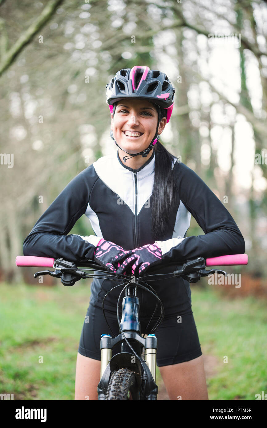 Portrait of smiling woman with mountain bike Stock Photo