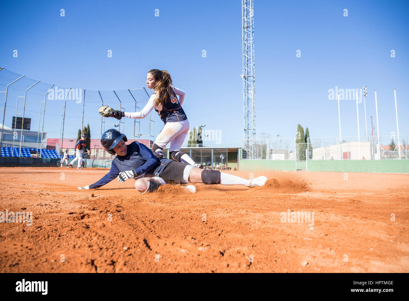 Baseball player sliding to the base during a baseball game Stock Photo