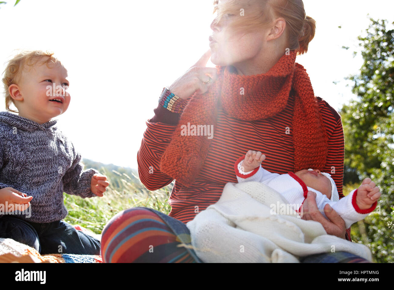 Mother with son and baby in meadow Stock Photo