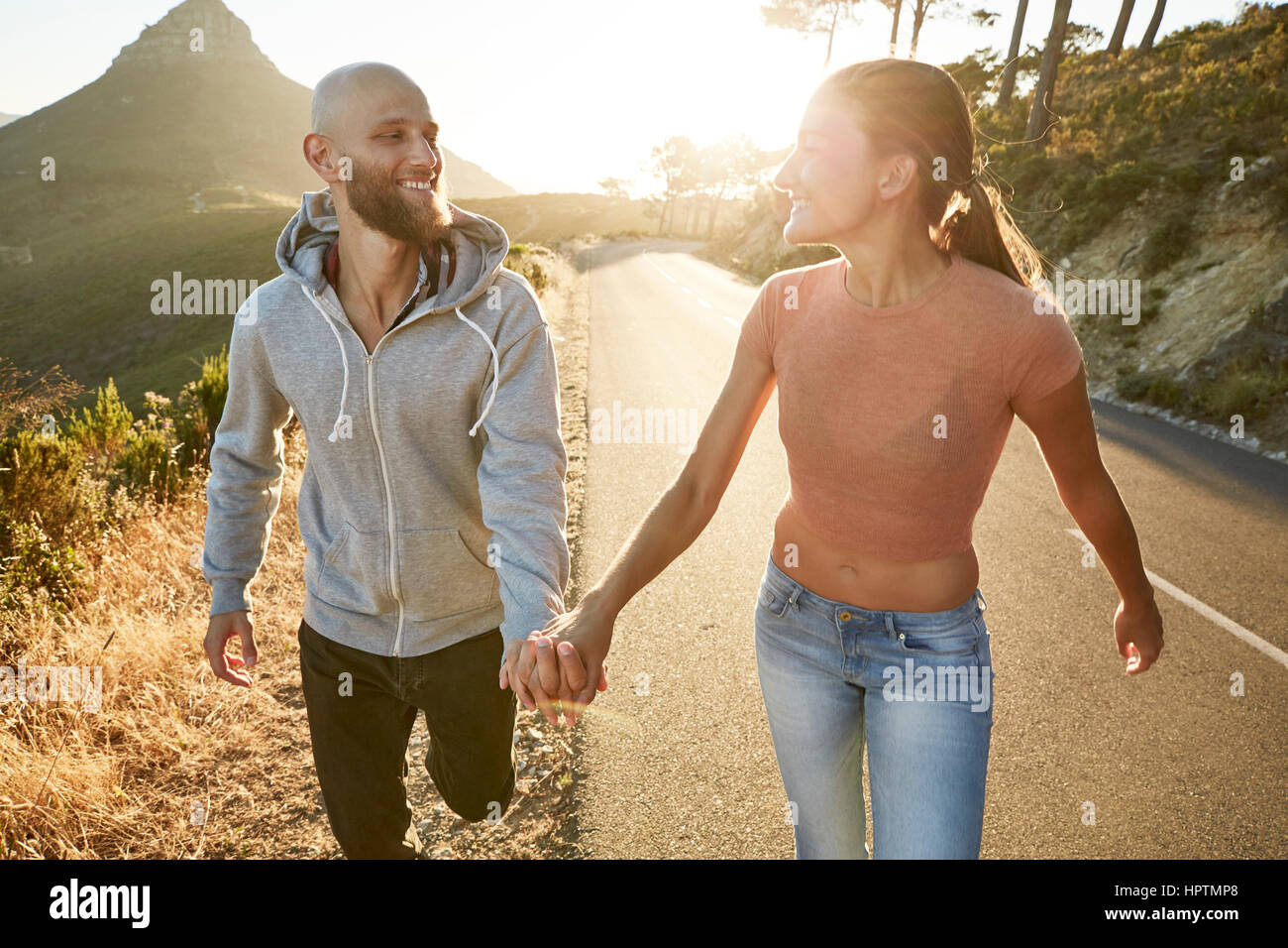 South Africa, Cape Town, happy young couple walking hand in hand at ...