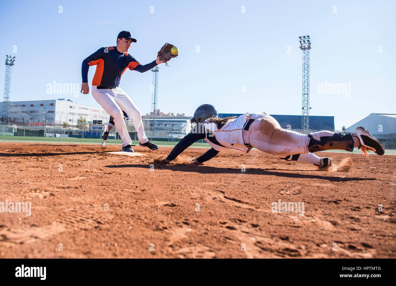 Baseball player sliding to the base during a baseball game Stock Photo