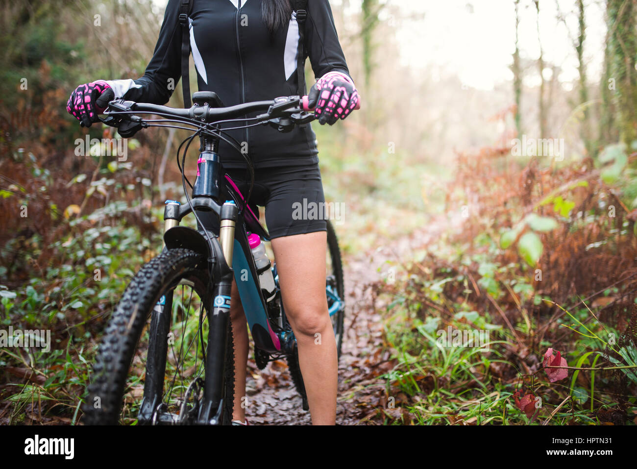 Female mountain biker on a trail in forest Stock Photo