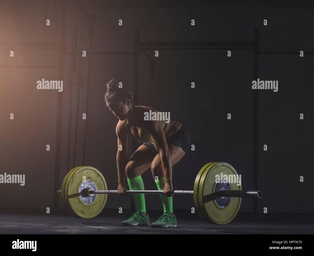 Young woman lifting barbell Stock Photo