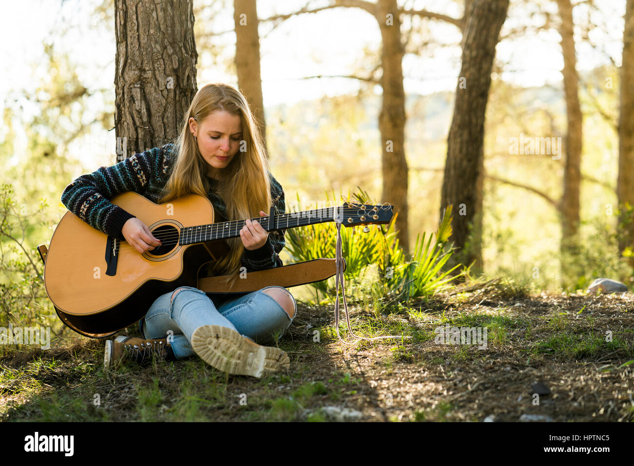 Young woman playing guitar in nature Stock Photo - Alamy