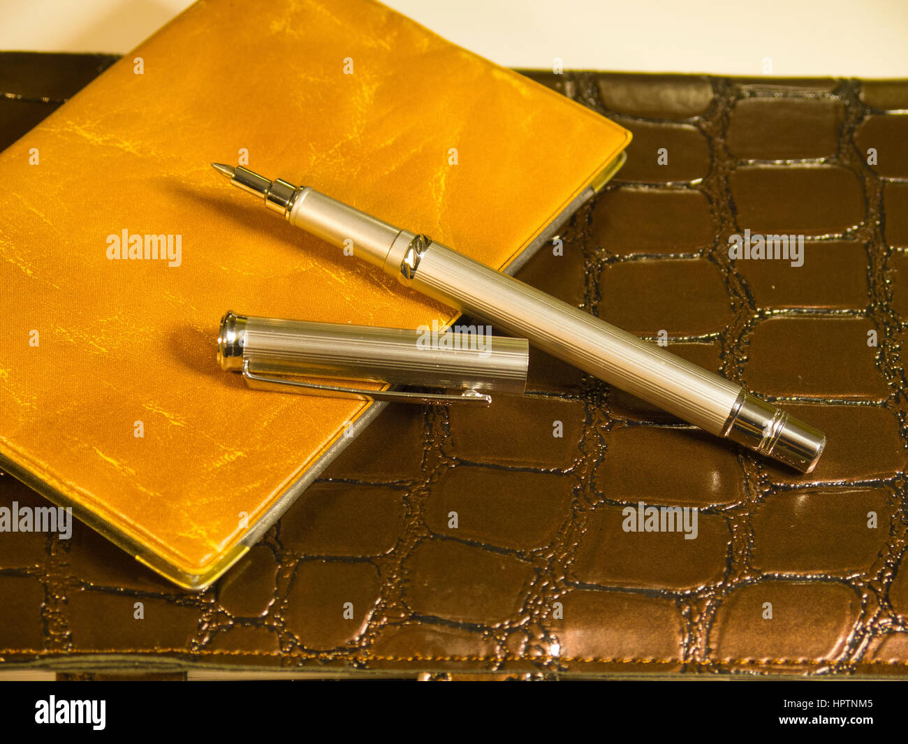 The purse, brown notepad and a steel pen Stock Photo Alamy