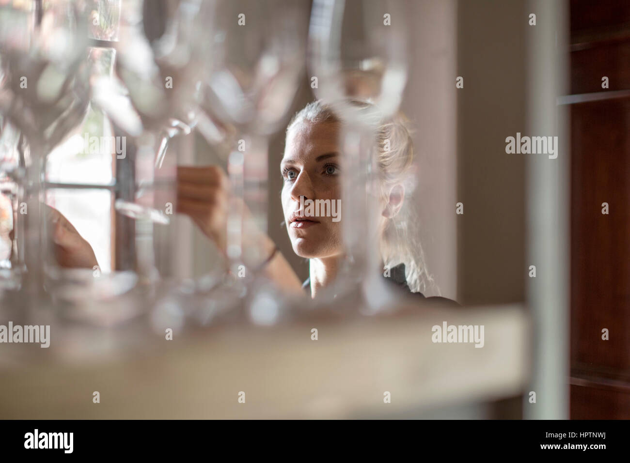 Waitress examining wine glasses Stock Photo