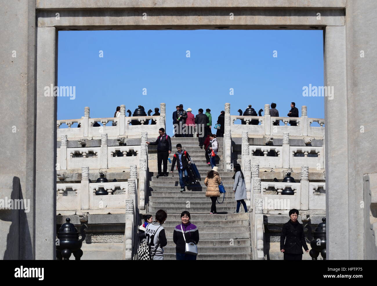 Chinese people visit and ascend the stairs to the Temple of Heaven altar in Beijing framed by its traditional architecture Stock Photo