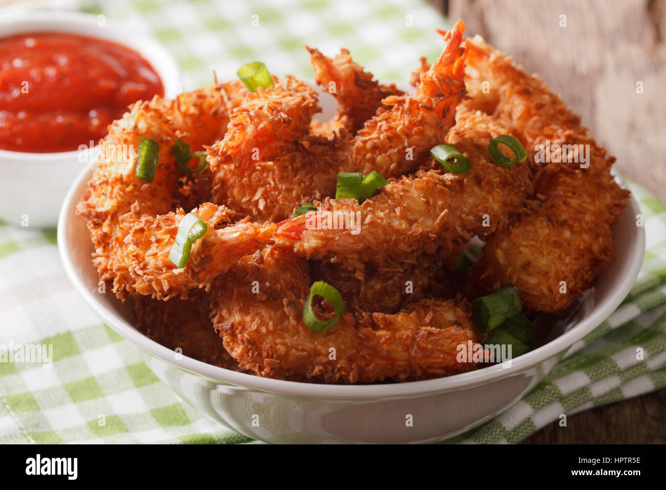 Fried shrimp in coconut breaded close up in a bowl and the sauce on the table. horizontal Stock