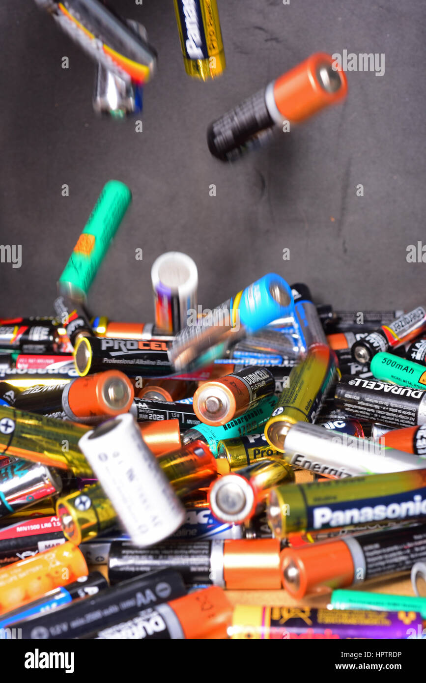 throwing old AA and AAA batteries into recycling box Stock Photo