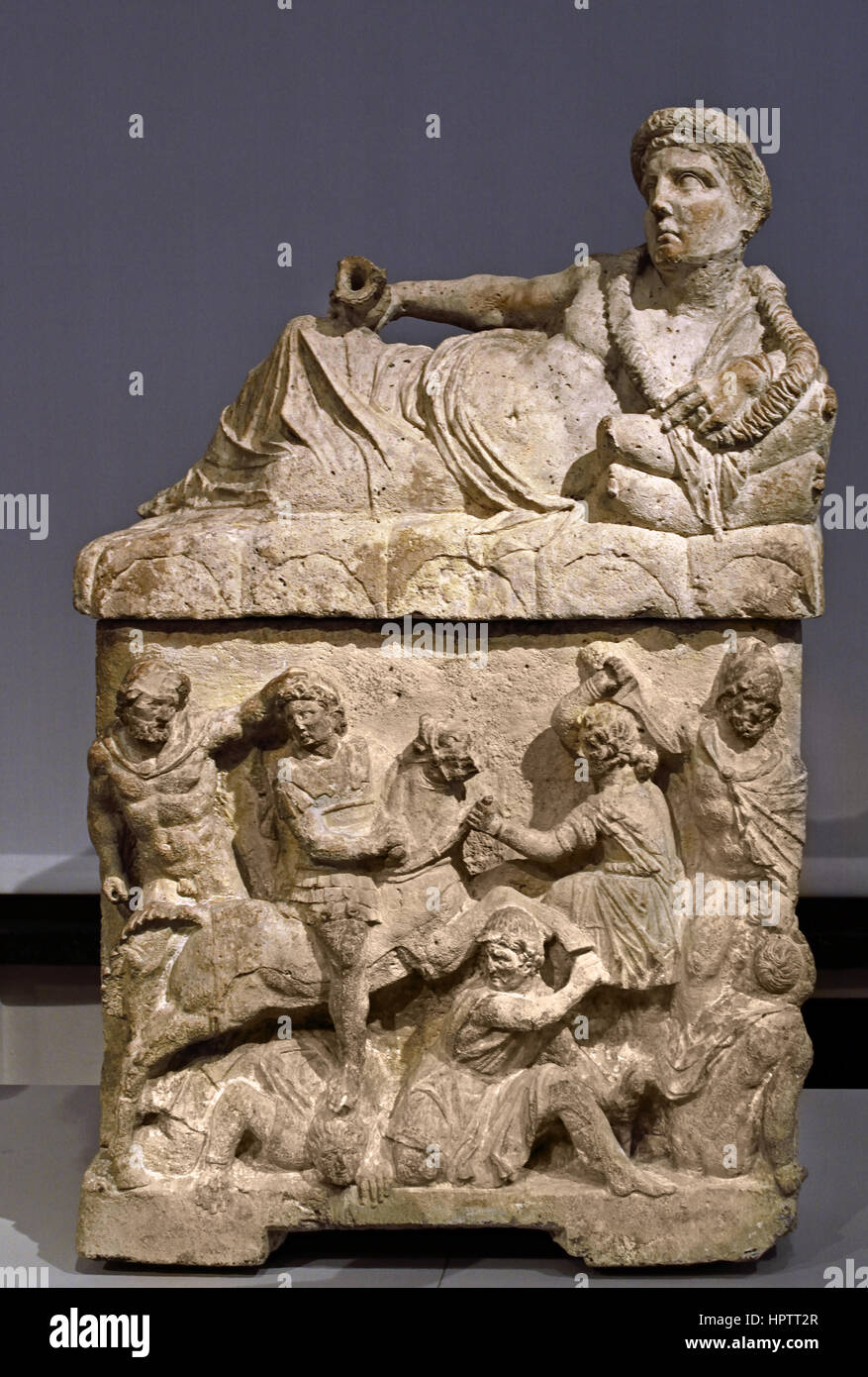 Cinerary Urn with Lid: Reclining Deceased with Kantharos; Perugia (Italy), 150 BC Italy  ( The front of the urn shows on the left the assassination of the trojan Prince Troilus by Achilles, and on the right a furious sword winds. The death of the young Troilos symbolizes the inescapability of fate. ) Etruscan,  Etruria, Tuscany, Stock Photo