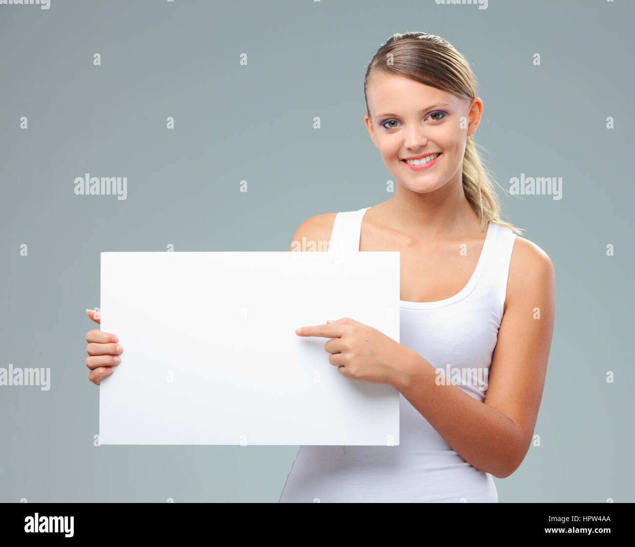 Portrait of a beautiful girl pointing at copy space Stock Photo - Alamy